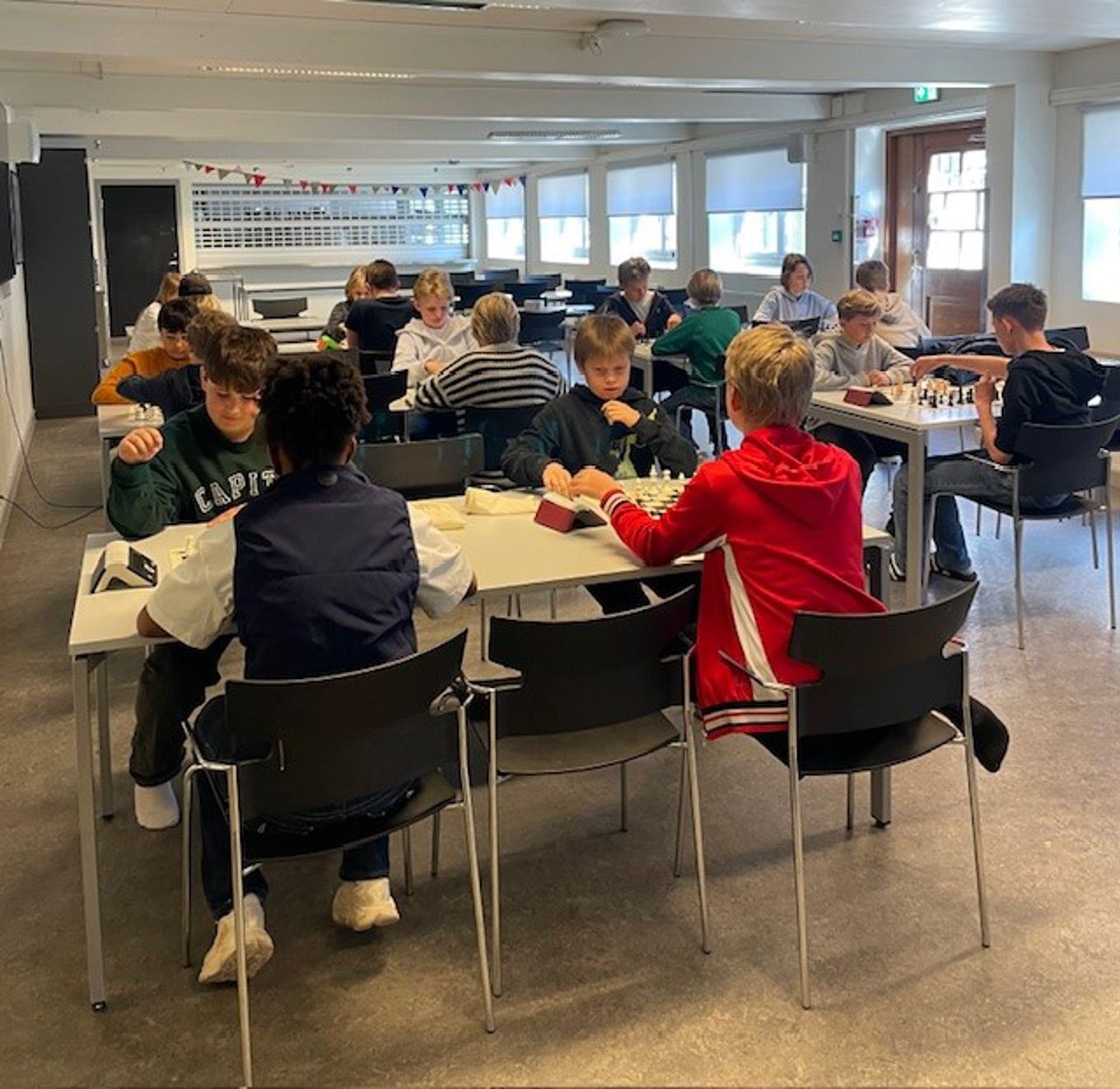 en gruppe mennesker som sitter ved bord og spiller sjakk en gruppe mennesker som sitter ved bord og spiller sjakk