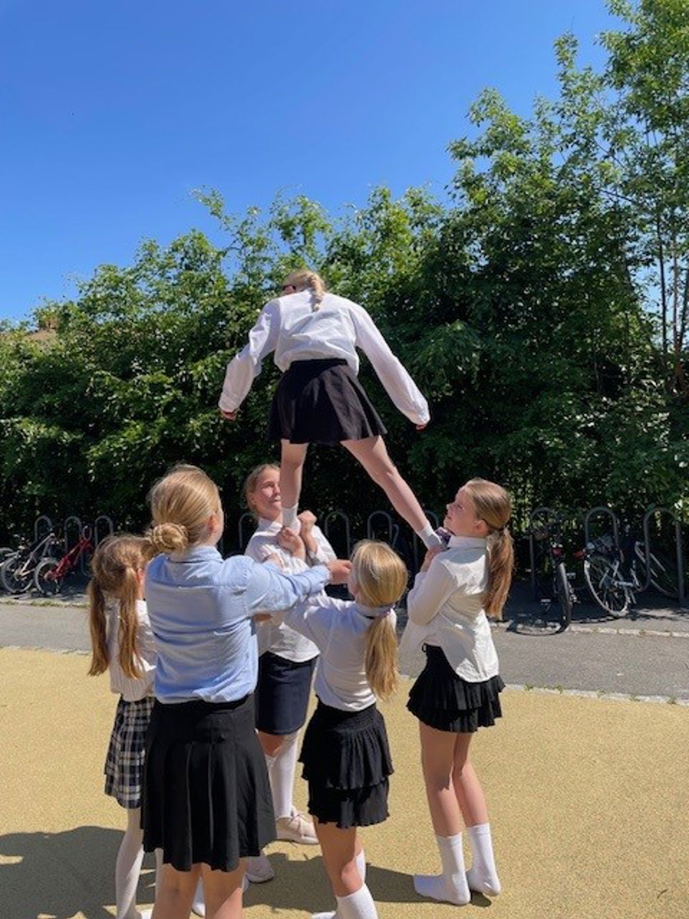 en gruppe barn som holder en person i luften