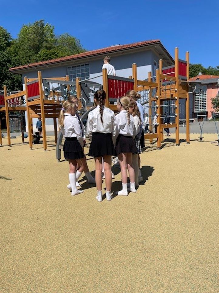 en gruppe barn som står på en lekeplass en gruppe barn som står på en lekeplass