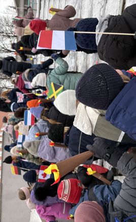 Elever går i parade med flagg fra ulike land