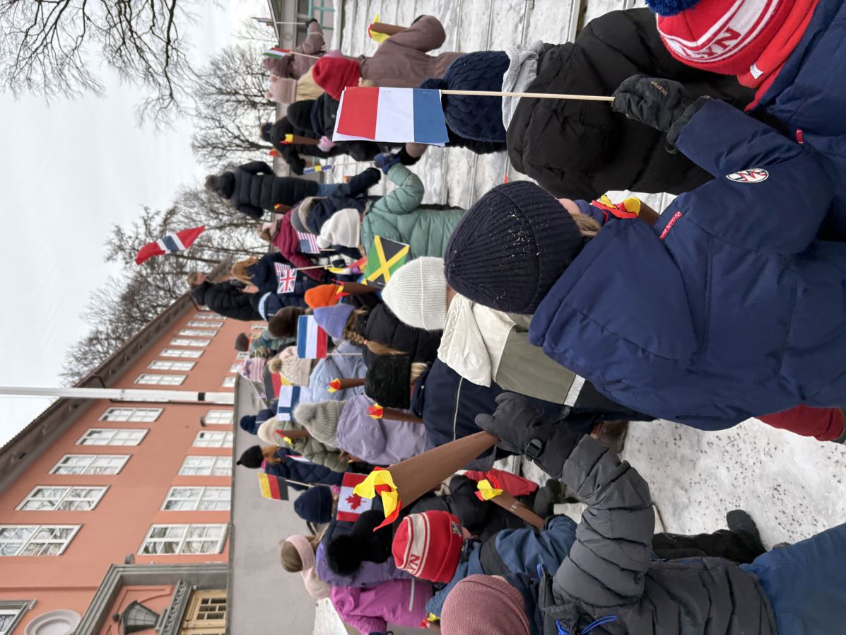 Elever går i parade med flagg fra ulike land