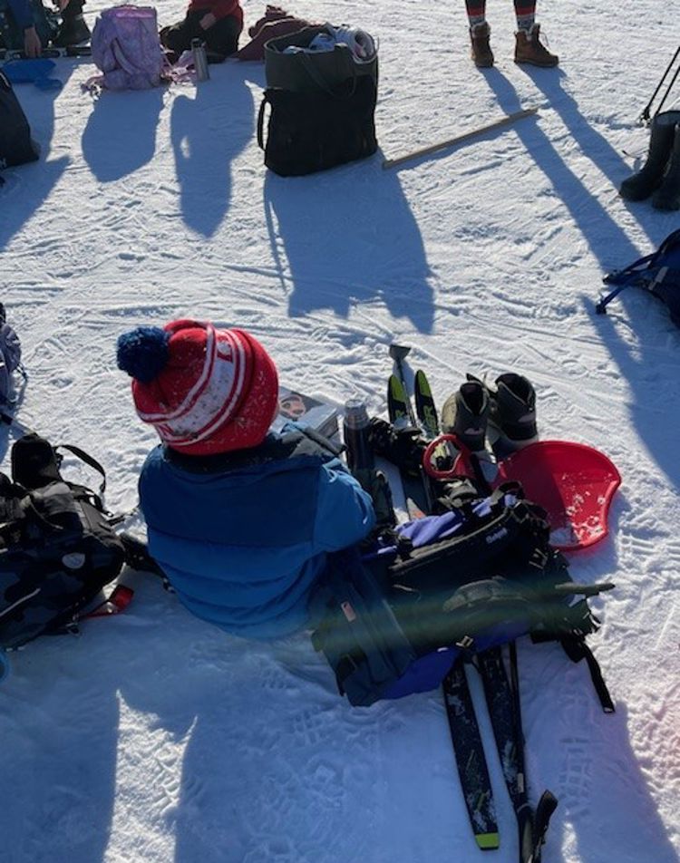 En elev sitter og tar pause i snøen