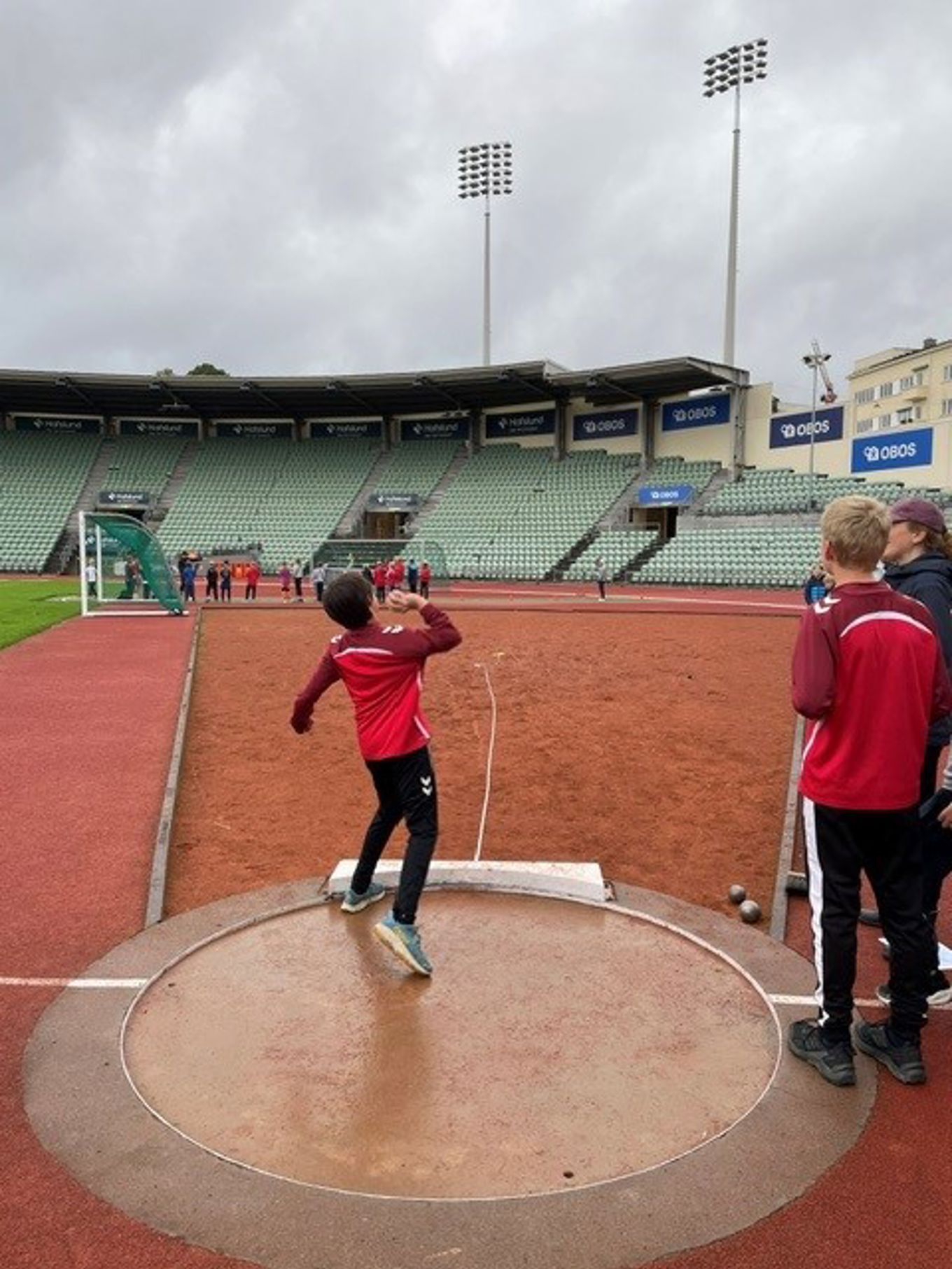 et barn som kaster kule på en stadion