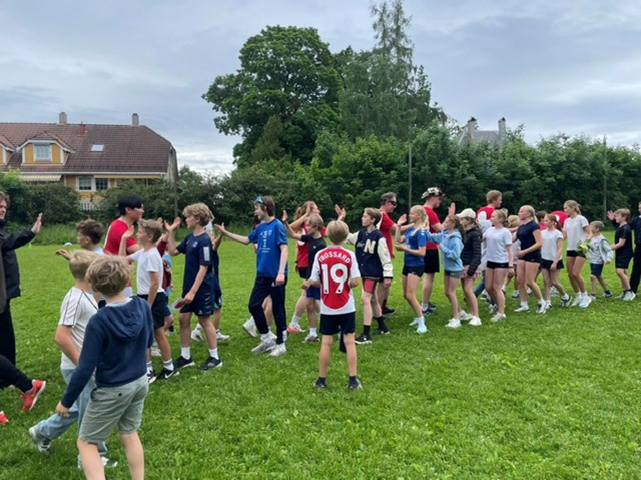 en gruppe mennesker som takker for kampen på en gressbane