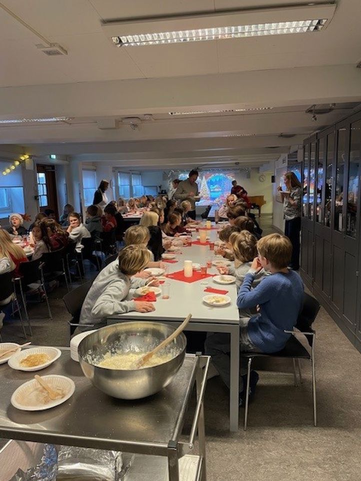 en gruppe mennesker som spiser grøt i kantinen